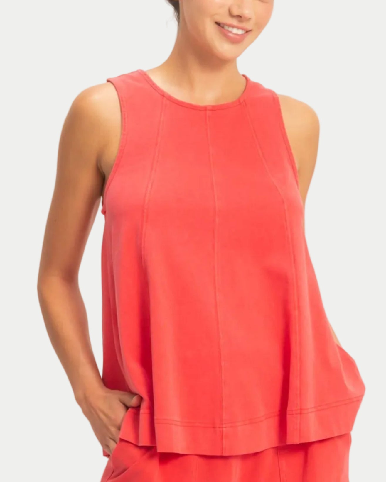 Woman wearing a red sleeveless swing top on a neutral background.  front view