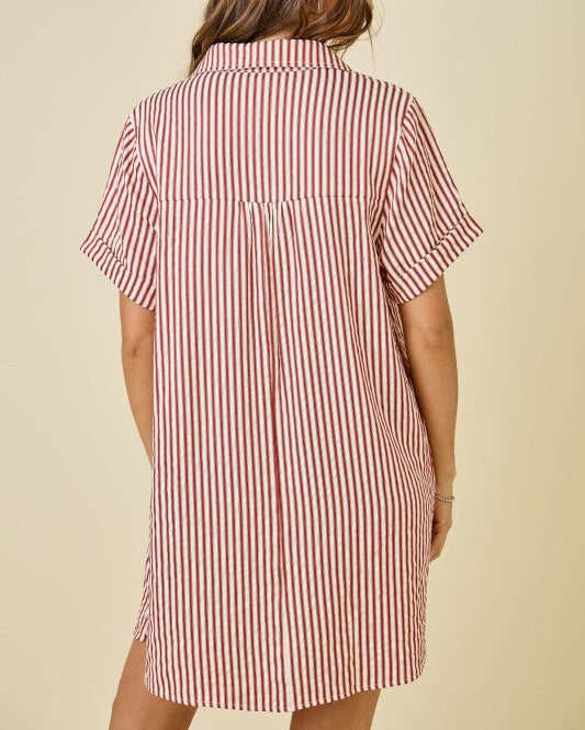 Woman wearing a red and white striped dress against a beige background