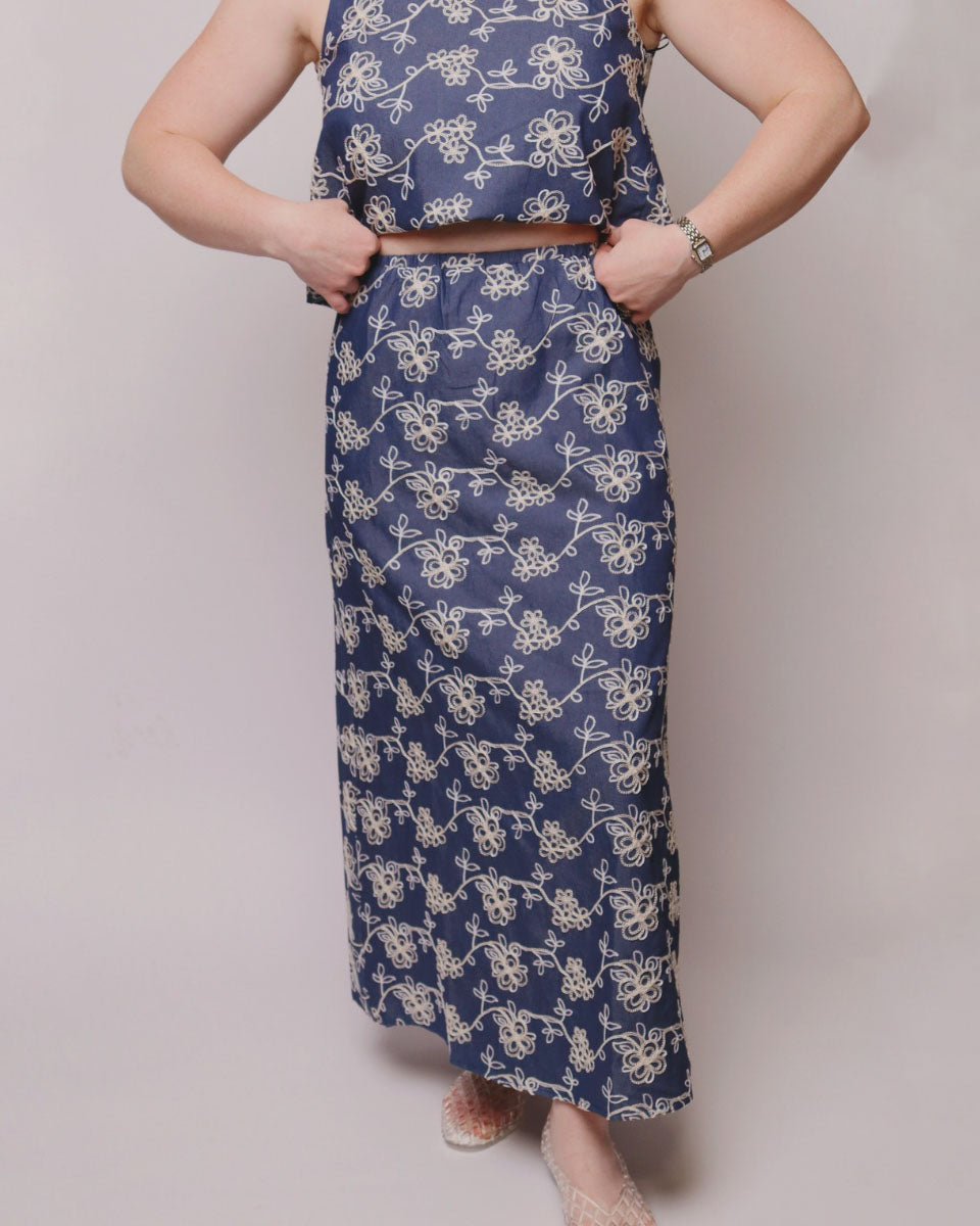 Person wearing a blue floral dress on a plain background