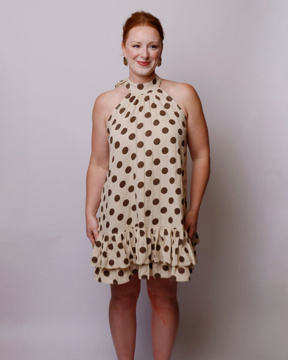 Woman wearing a polka dot dress against a plain background