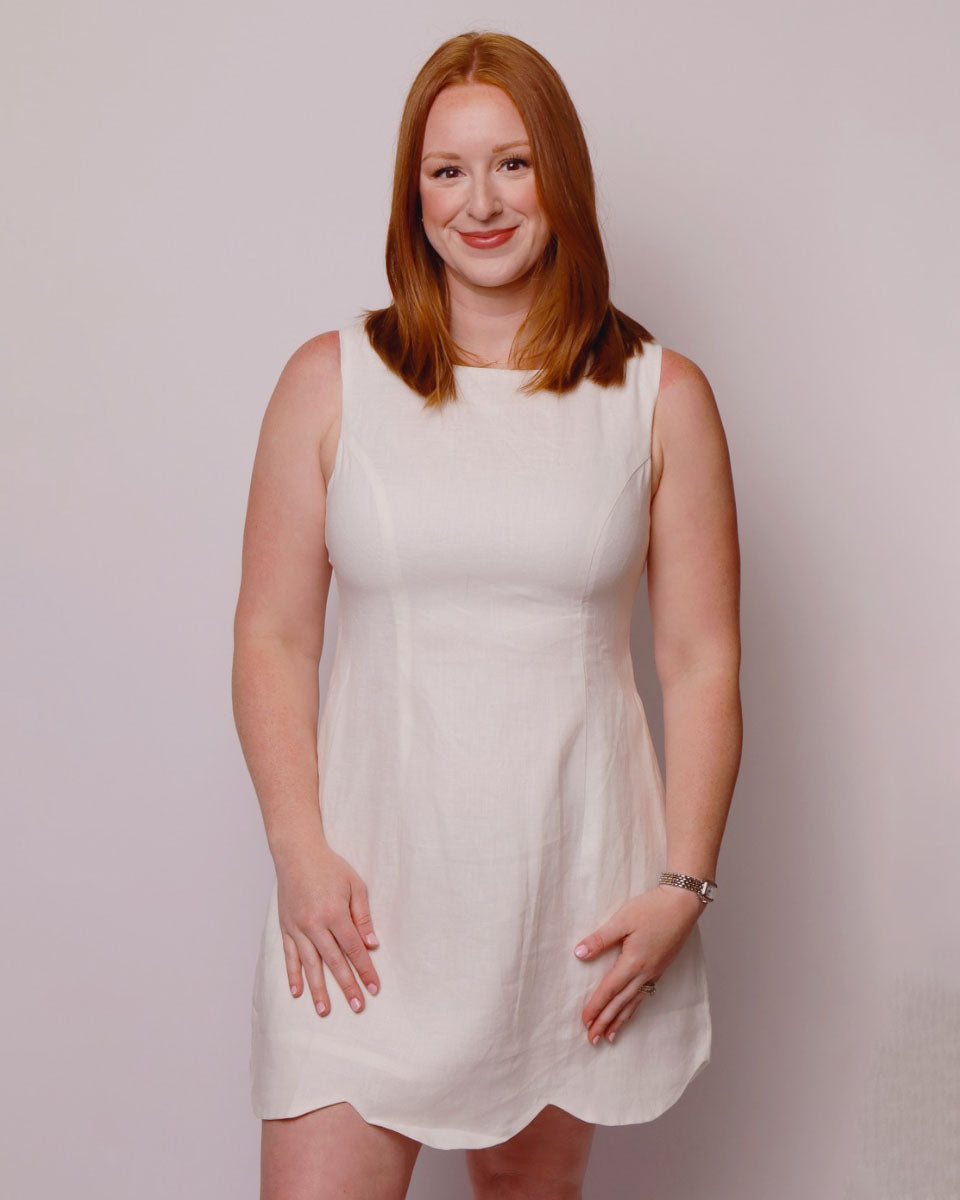Woman wearing a white dress against a plain background