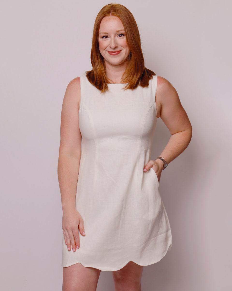 Woman wearing a white dress against a plain background