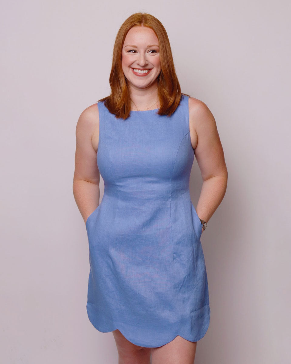Woman wearing a blue dress against a plain background