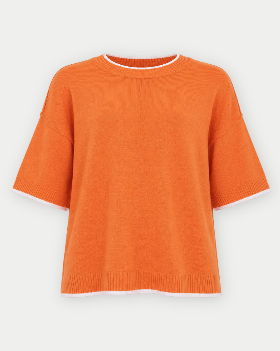 An orange short-sleeve knit sweater with white contrast trim along the collar, sleeve cuffs, and hem, displayed against a light gray background.