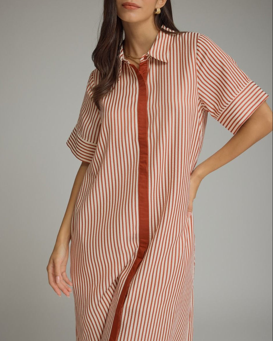 Woman wearing a striped dress with a red accent on a gray background