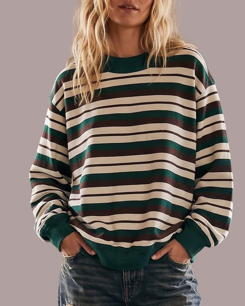 A model wearing a striped sweatshirt in brown, cream and hunter green on a neutral background