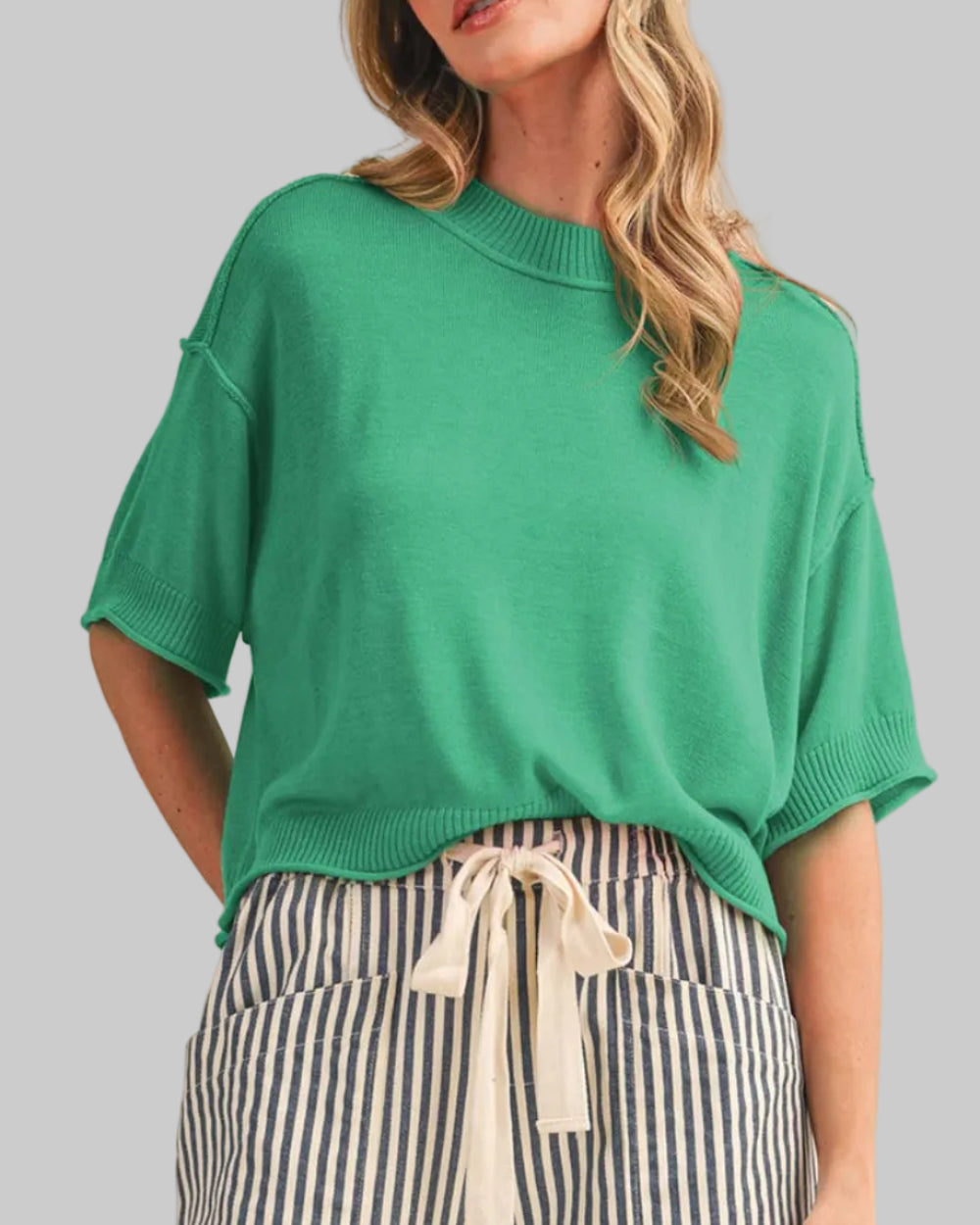 LIGHTWEIGHT KNIT MOCK NECK SHORT SLEEVE SWEATER in green on a model with a neutral background