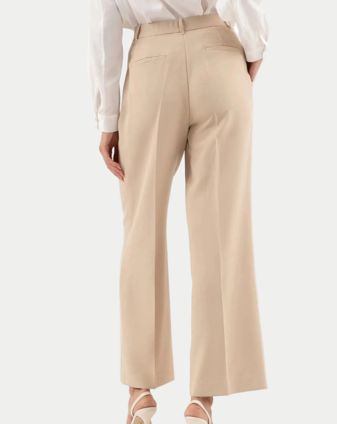 Beige wide-leg pants worn with a white shirt on a white background