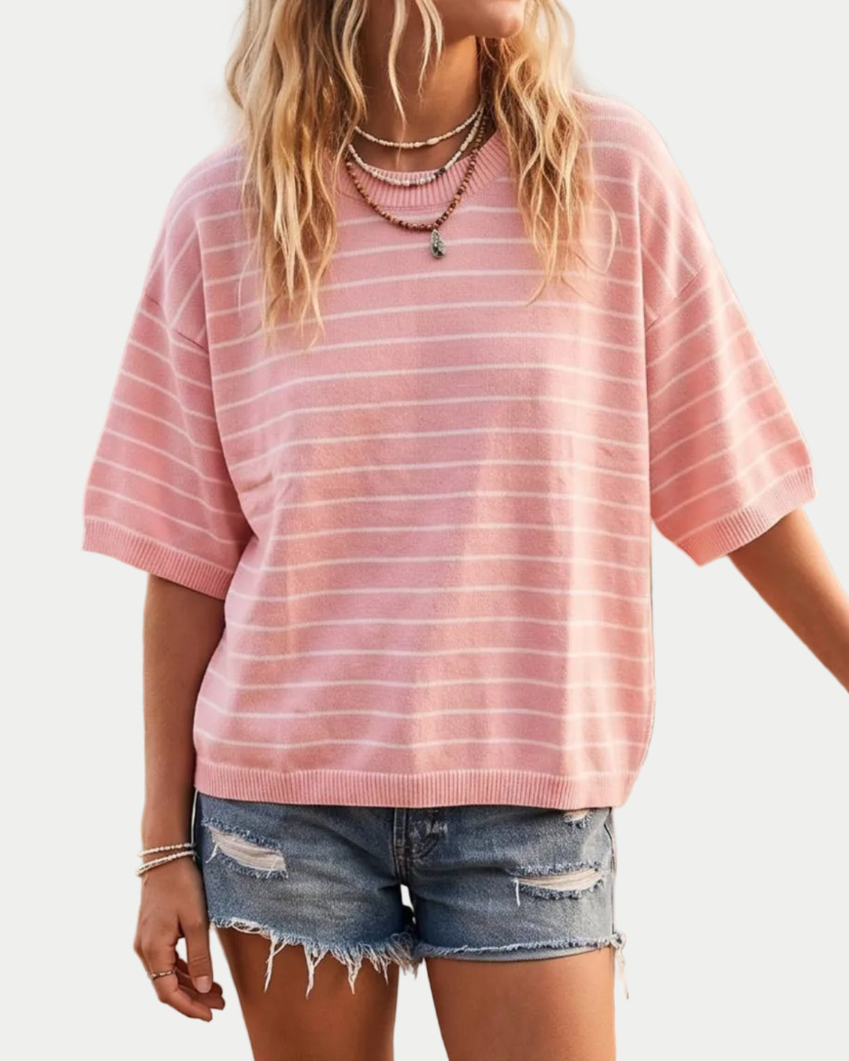 Model in a pink striped shirt on a neutral background.
