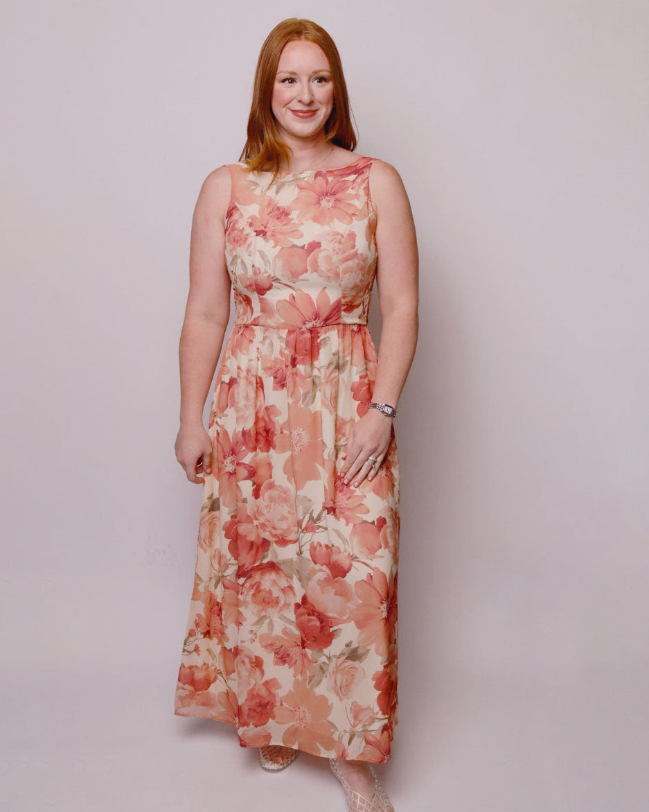 Woman wearing a floral dress against a plain background. Front view
