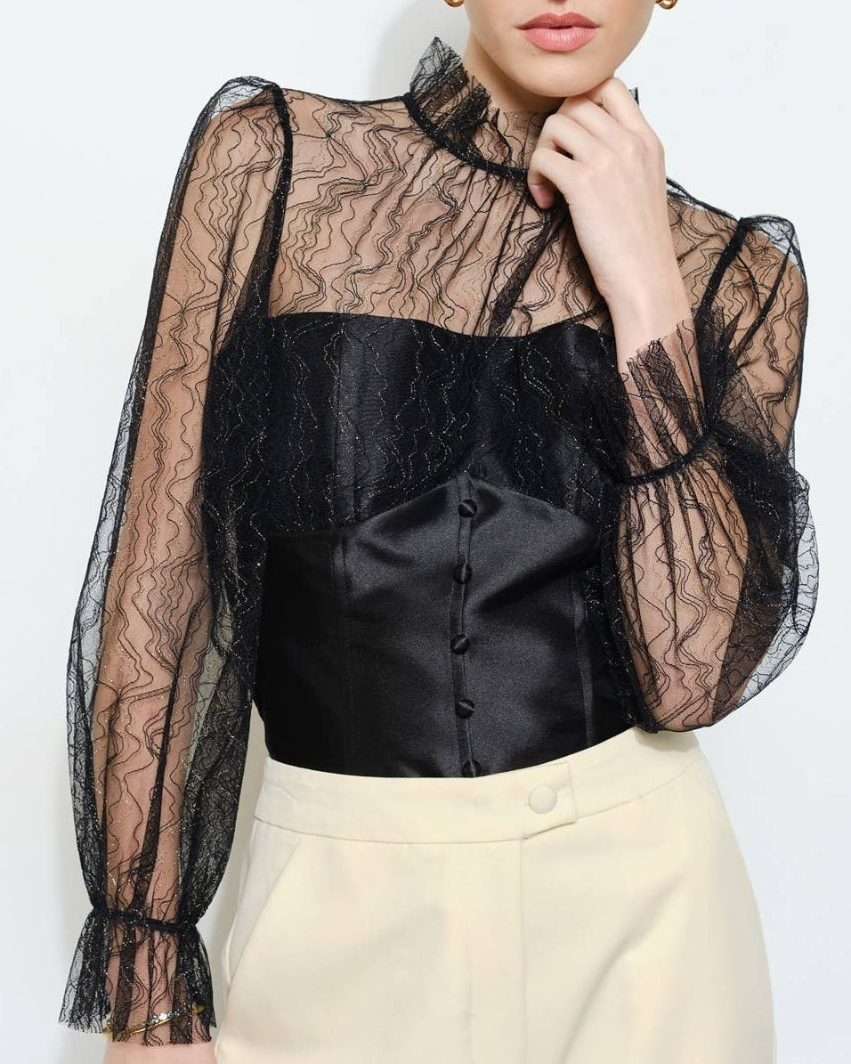 Model wearing a black lace top on a neutral background
