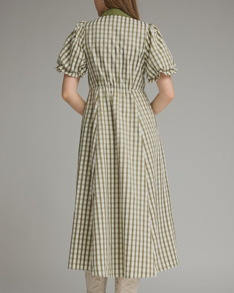 Woman wearing a green and white checkered dress on a gray background