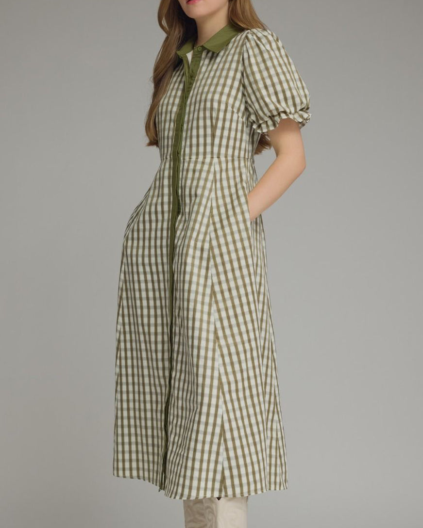 Woman wearing a green checkered dress with a plain background