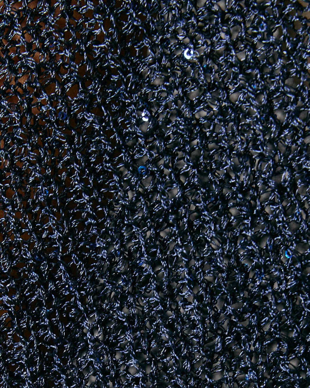 Close-up of a textured navy sequin fabric surface