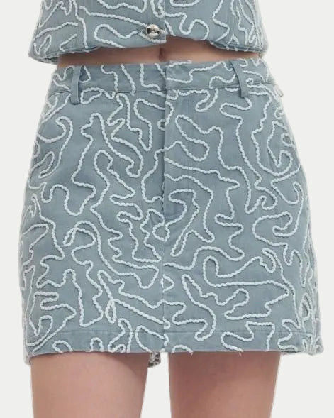 Person wearing light blue patterned shorts on a white background