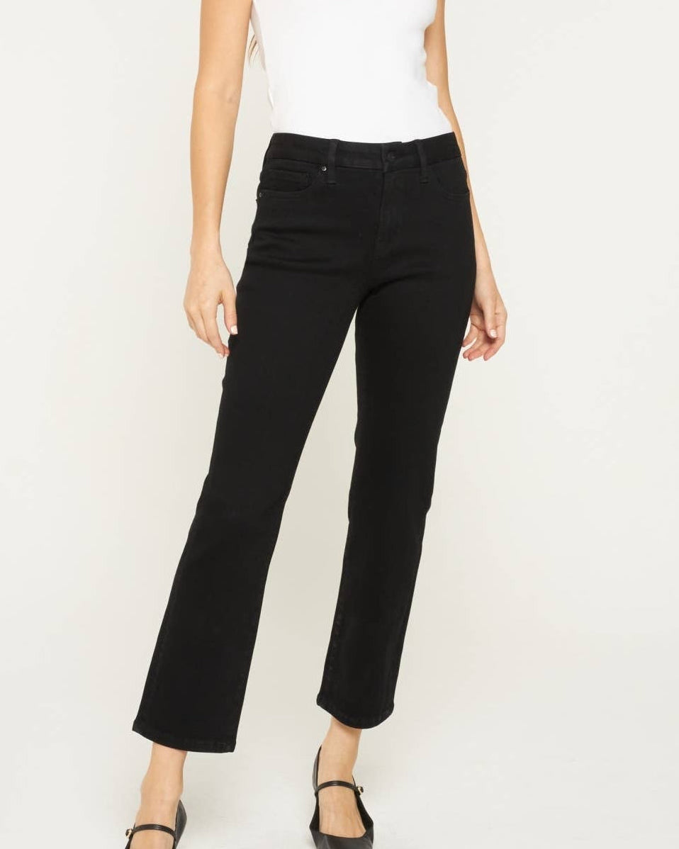 Model wearing black ankle length denim.  Mid rise.  on a neutral background