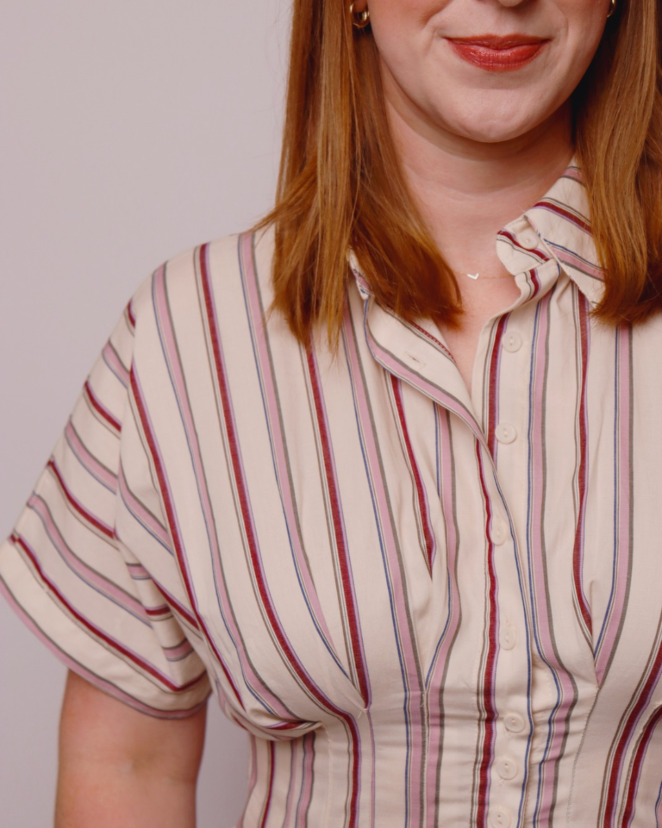 Woman wearing a striped shirt dress with a plain background