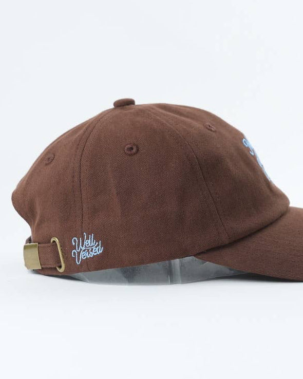Brown baseball cap with a visible brand logo on a white background