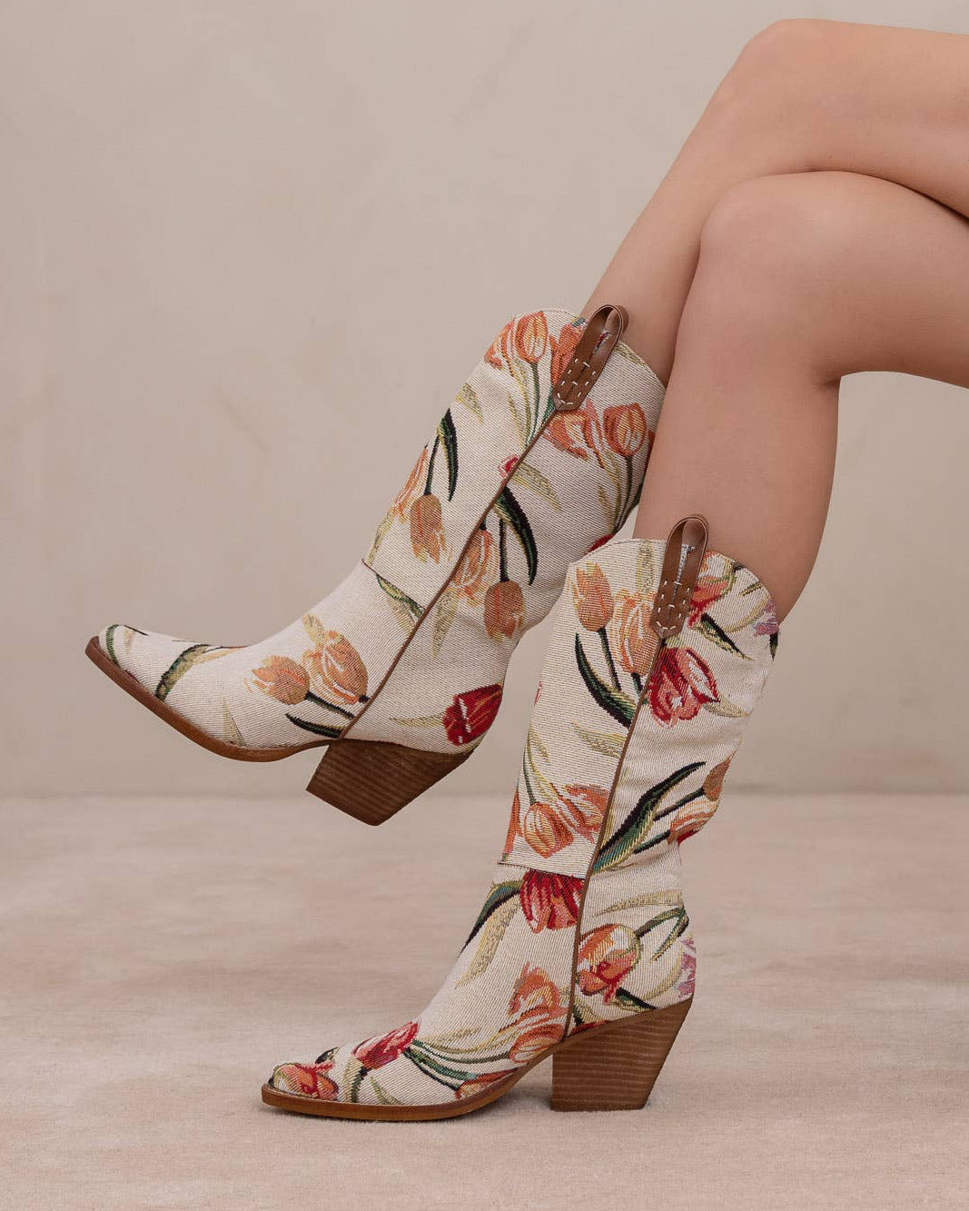 Floral patterned boots worn by a person sitting on a chair.