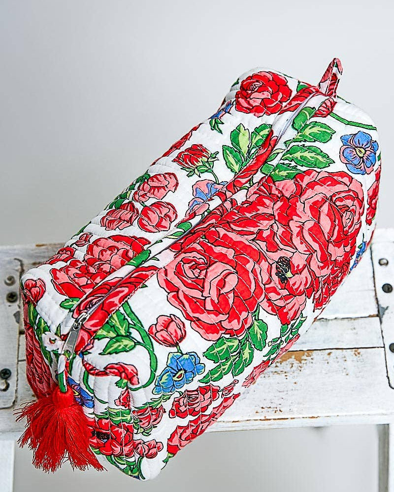 Floral-patterned bag with red roses on a white wooden surface