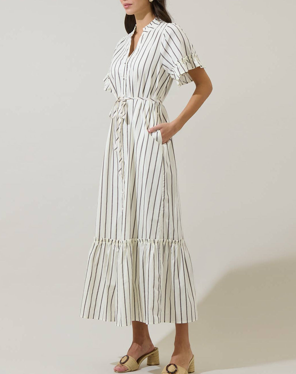 Woman wearing a striped dress against a plain background