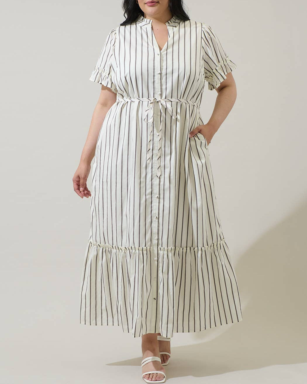 Woman wearing a striped dress against a plain background