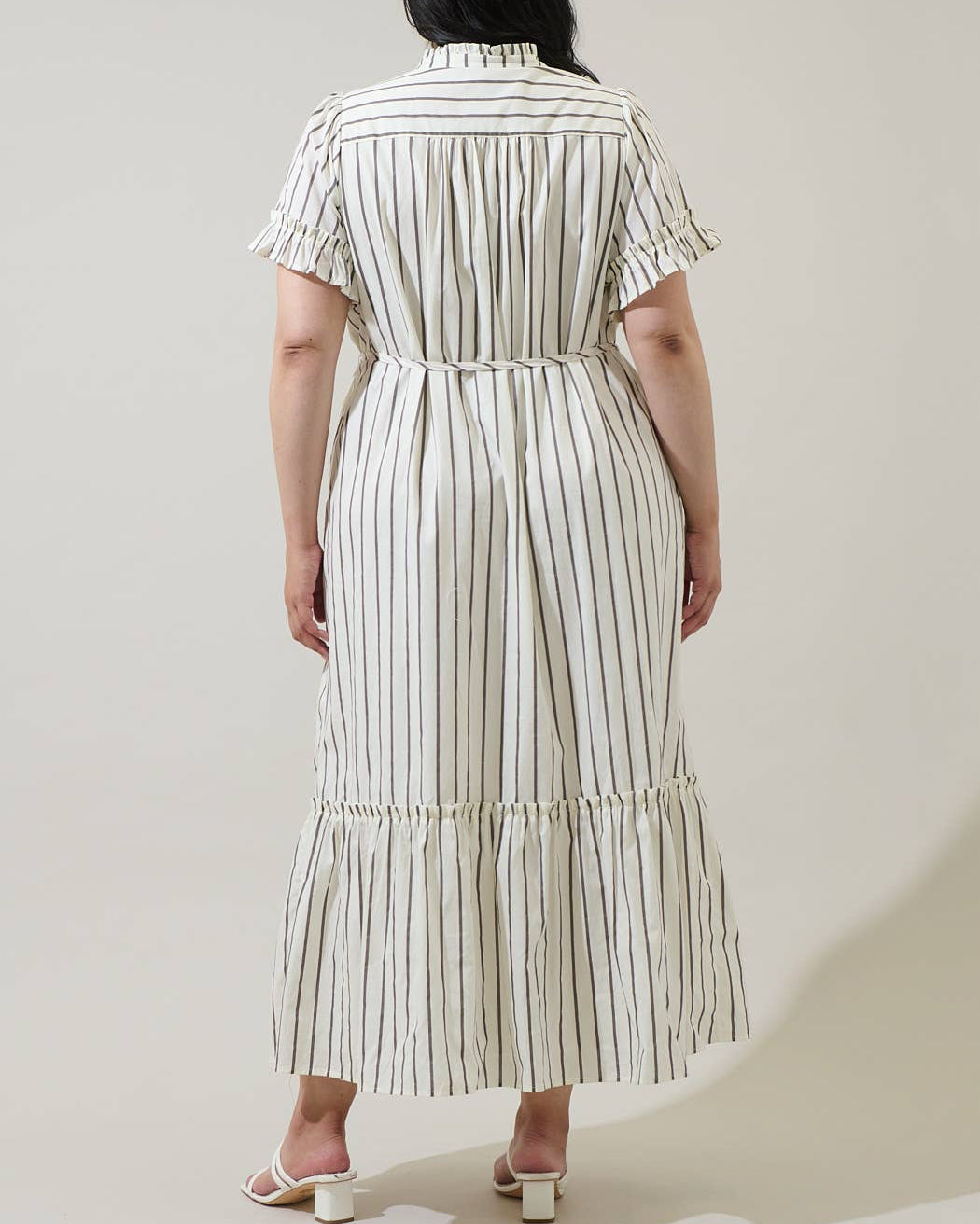 Woman wearing a striped dress against a plain background