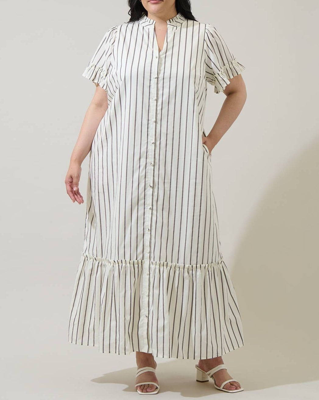 Woman wearing a striped dress against a plain background