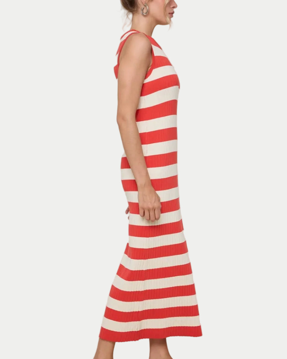 Woman wearing a papaya and white striped dress on a plain background