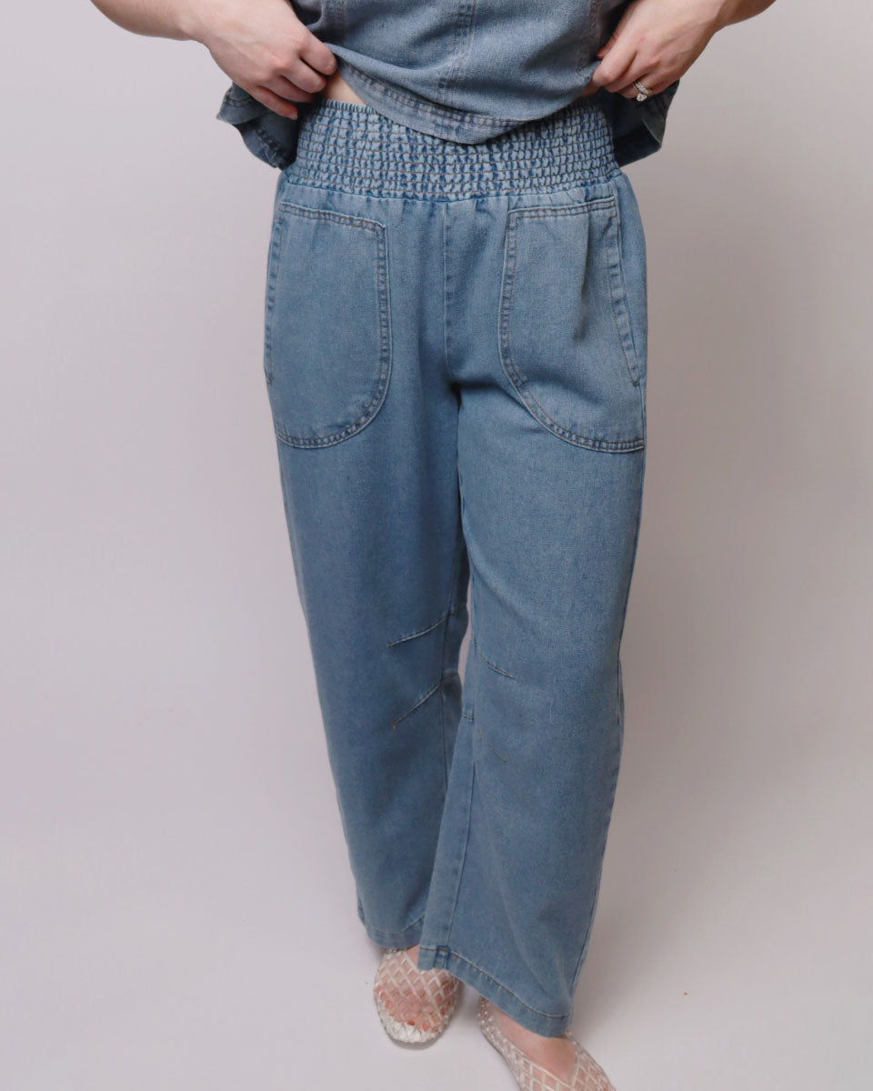 Person wearing blue denim pants on a plain background