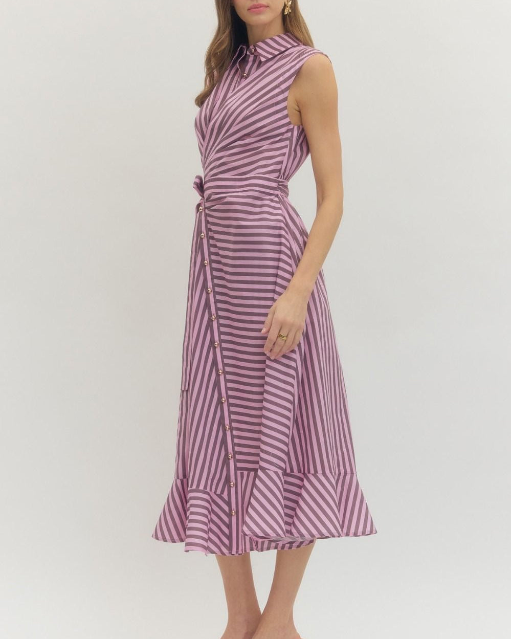 Woman wearing a sleeveless, striped dress on a white background