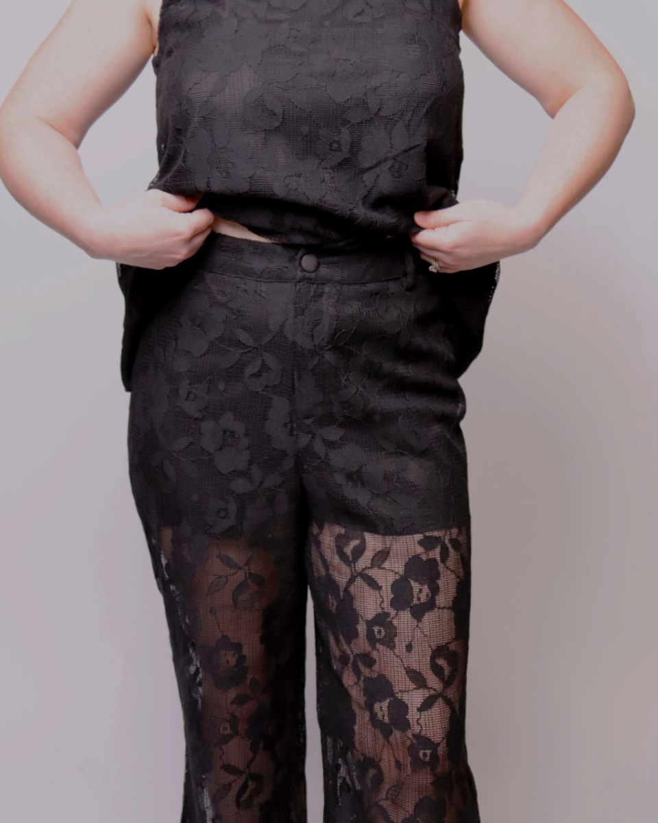 Person wearing a black floral patterned outfit on a plain background