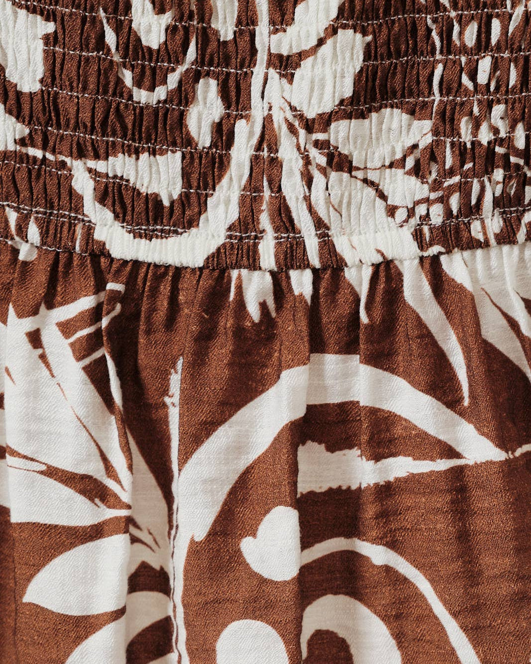 Close-up of brown fabric with white floral pattern