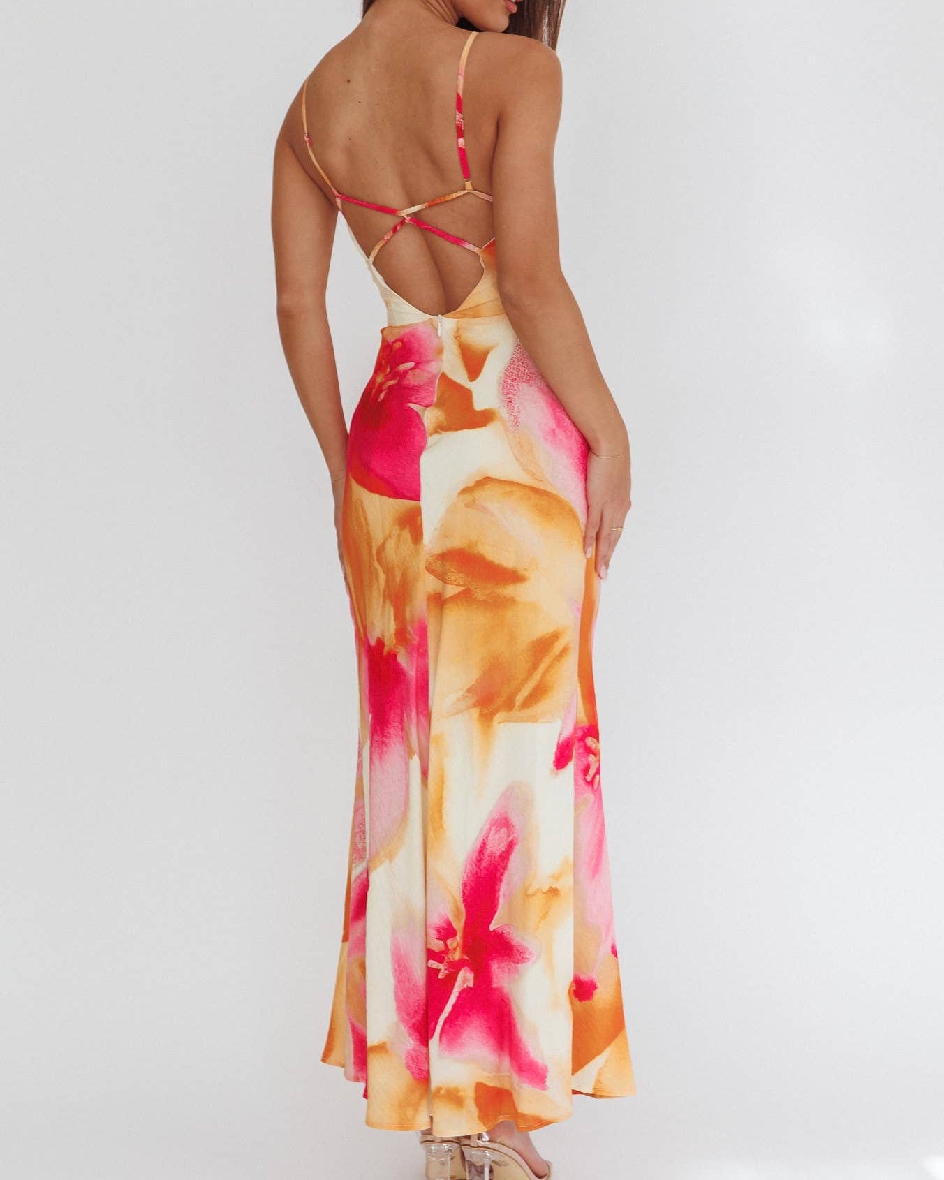 Woman wearing a colorful floral dress with a white background