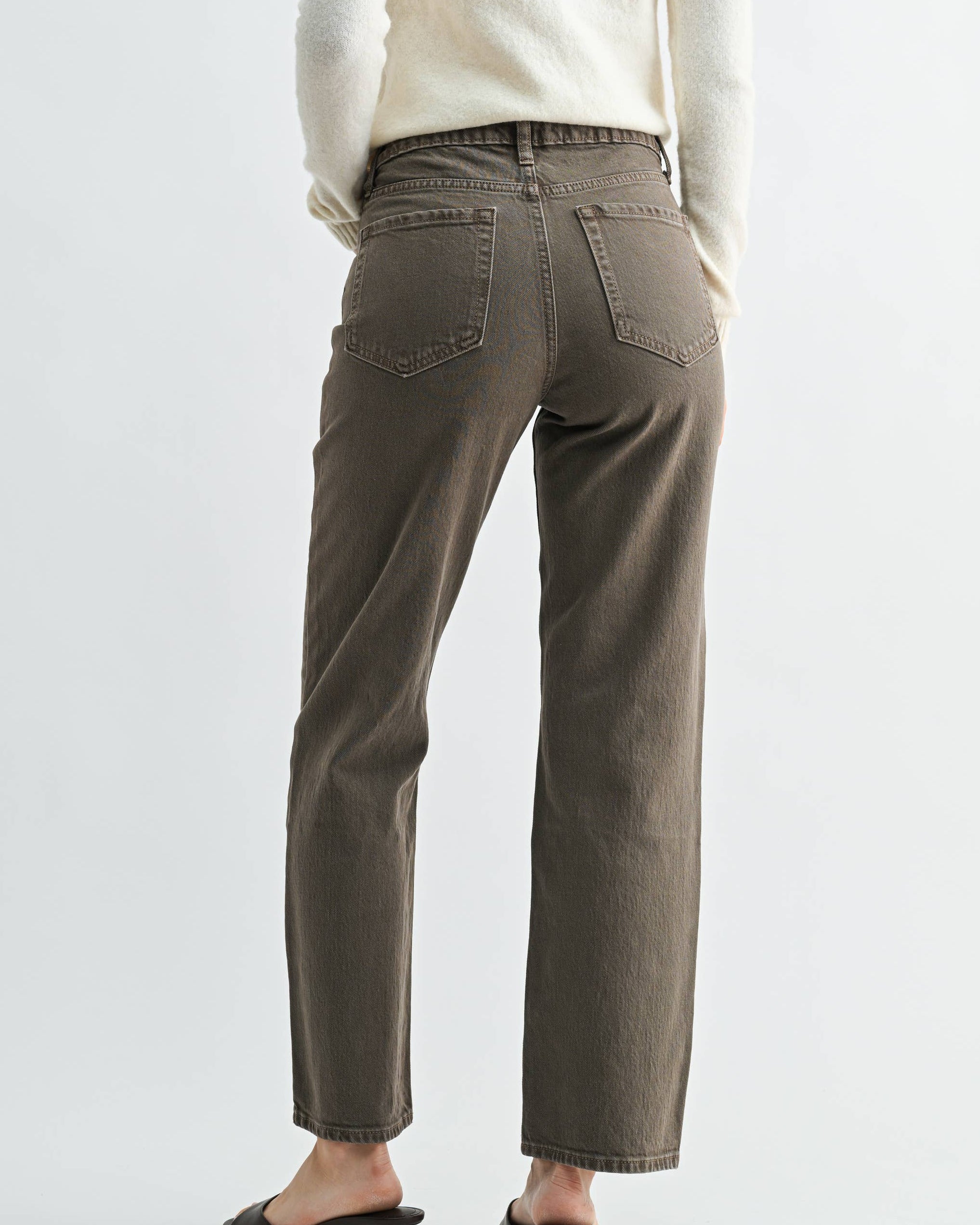 A model wearing a pair of vintage brown straight-leg jeans on a neutral background. back view