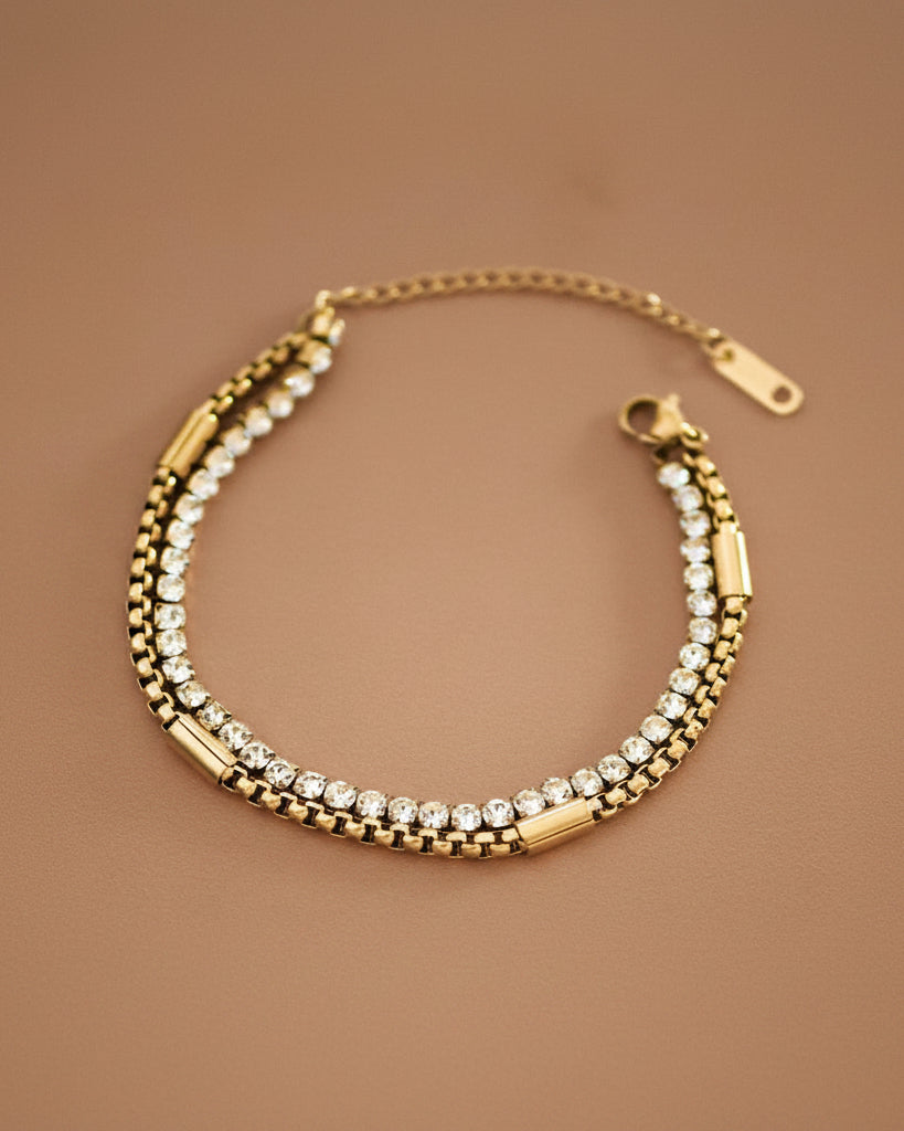 Gold bracelet with clear stones on a brown background