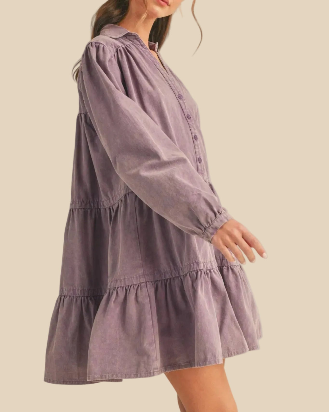 Woman wearing a purple dress against a plain background - side view