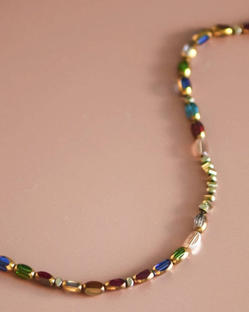 Multicolored beaded necklace on a pink background