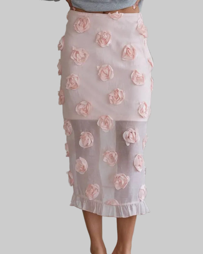 Person wearing a light pink floral skirt against a plain background