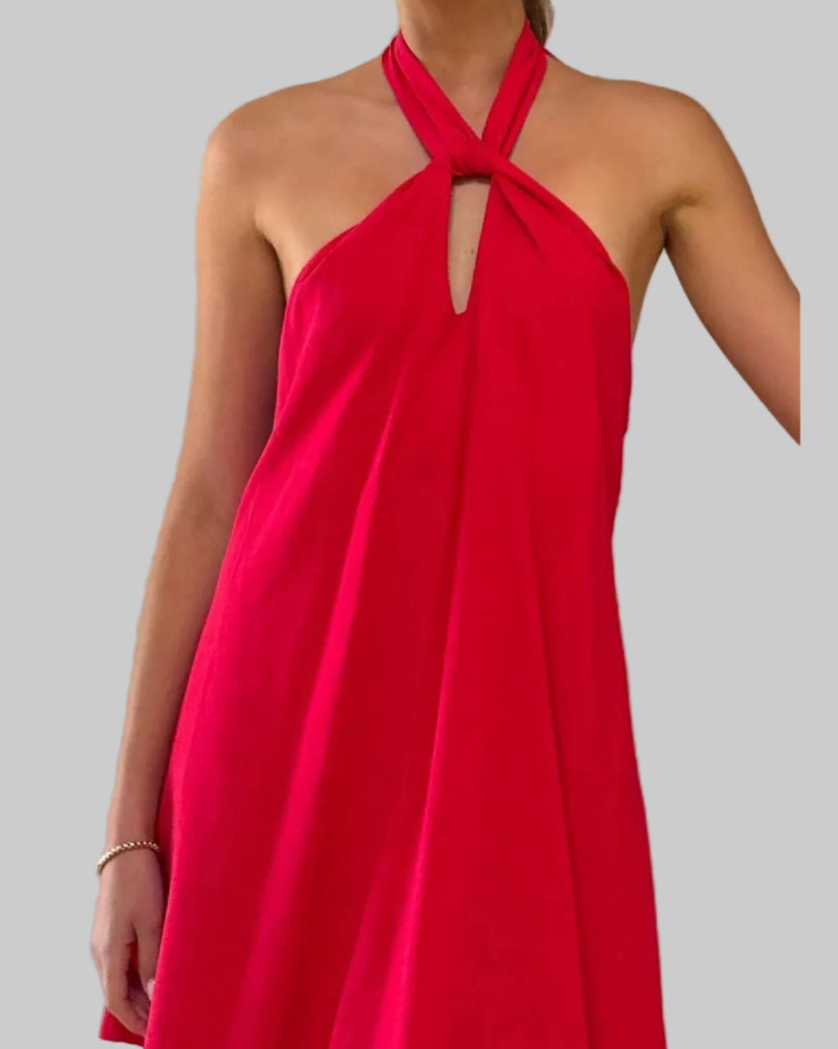 Red halter neck dress worn by a person against a neutral background